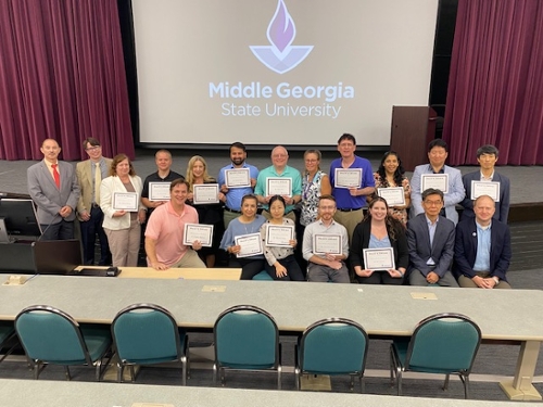 The School of Computing poses with awards for a group photo at their awards ceremony.